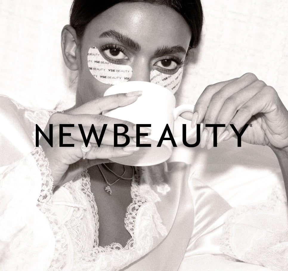 NewBeauty feature: wearing Overachiever Brightening Eye Masks while holding a coffee cup