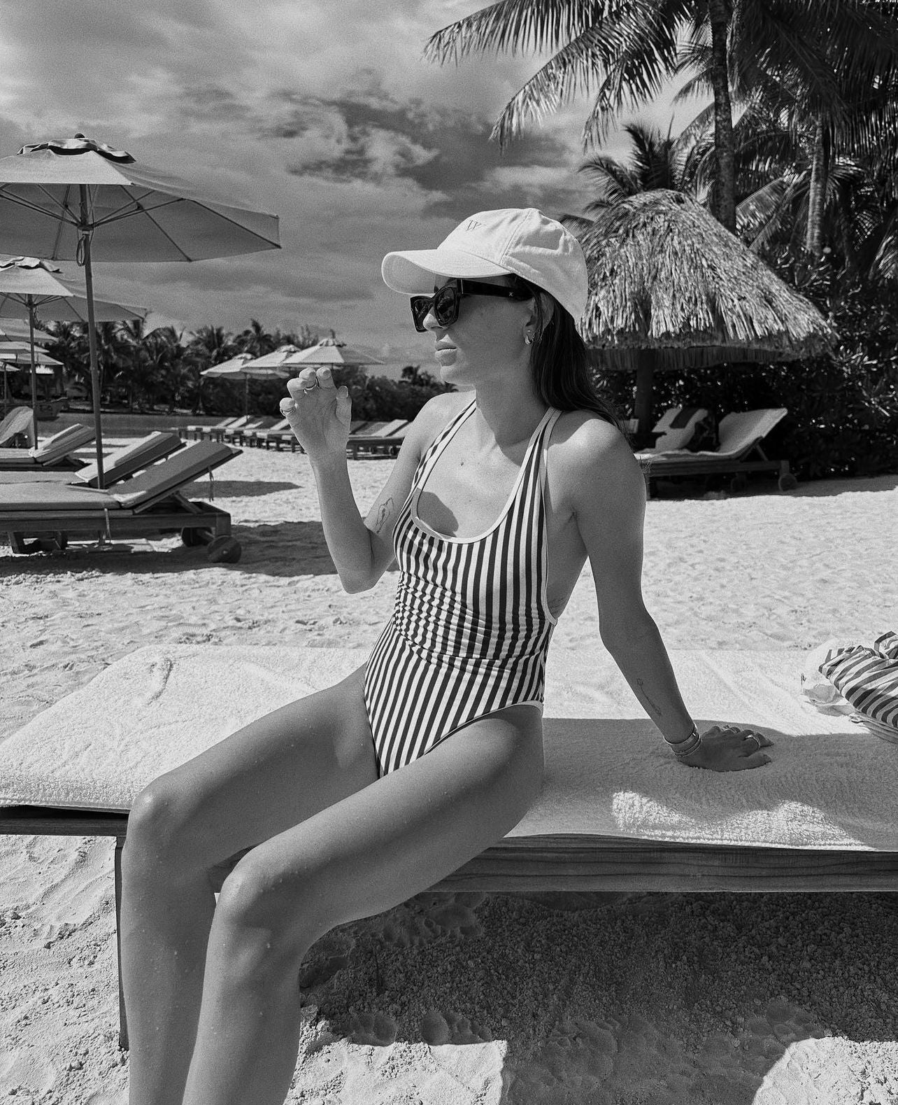Woman relaxing at the beach in a striped swimsuit