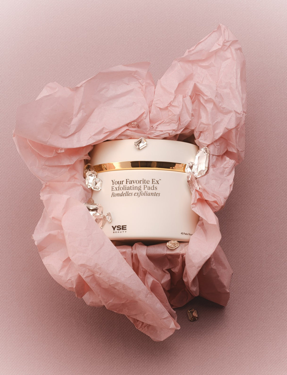 Your Favorite Ex Exfoliating Pads jar nestled in crumpled pink tissue paper
