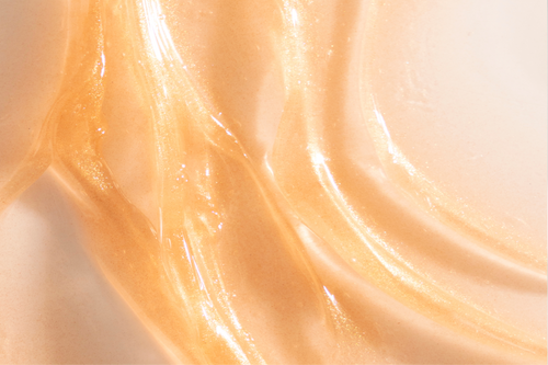 Close-up texture of a shimmering gold-toned serum