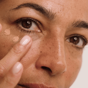 Blending Wide Awake Brightening Eye Cream into the under-eye with a fingertip.