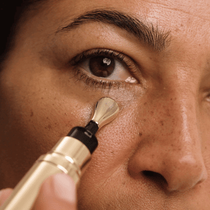 Applying Wide Awake Brightening Eye Cream under the eye with its cool metal tip.