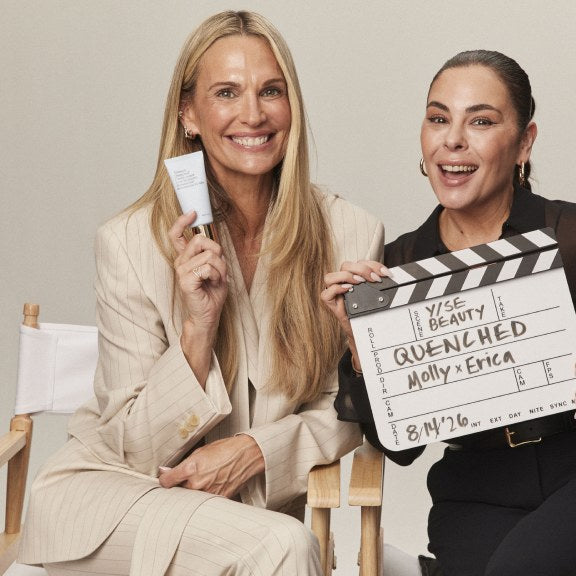 Molly Sims holding a clapperboard beside makeup artist Erica Taylor on set.